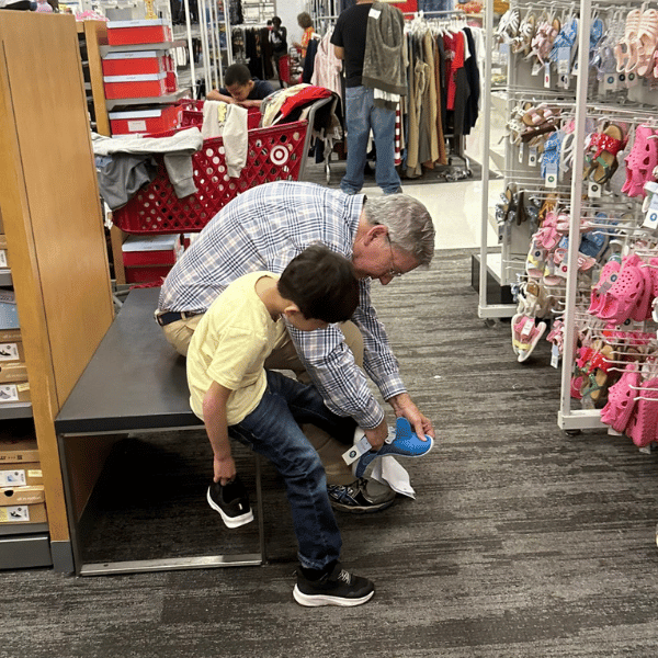 Volunteer Helping Child at Childspree Event